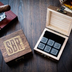 Pu&ograve; includere: Una scatola di legno con le iniziali "SBR" incise sul coperchio. La scatola contiene sei pietre per whisky quadrate nere con le stesse iniziali incise su ogni pietra.