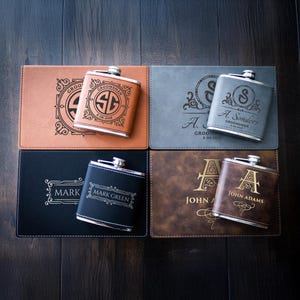 May include: Four personalized leather-wrapped flask sets with engraved initials and names. Each set includes a silver flask and a brown, black, or gray leather case.