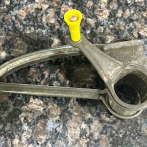 May include: Vintage metal cheese grater with a yellow handle. The grater has a crank handle and a round grating surface.