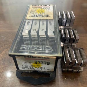May include: A set of RIDGID high-speed steel universal pipe dies, model 47770, with inserts numbered 1 through 4. The dies are in a clear plastic case with the RIDGID logo and product information.