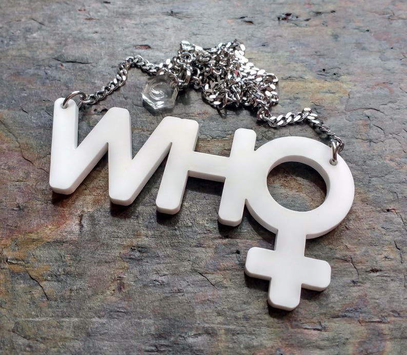 May include: A white necklace with a pendant that says "WHO" with a female symbol attached to the "O".
