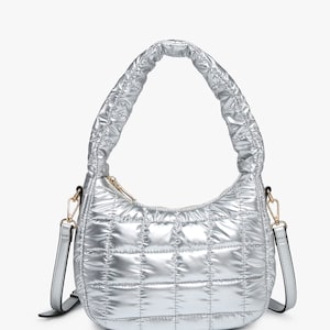 May include: A silver quilted shoulder bag with a single strap. The bag has a zipper closure and a puffy, quilted design.