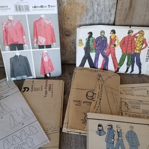 May include: A collection of vintage Vogue sewing patterns, including patterns for jackets, tops, and pants. The patterns are in various colors and styles, and some have illustrations of the finished garments.