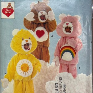 May include: Butterick sewing pattern featuring Care Bears costumes. The image shows three Care Bear costumes: a brown bear with a heart, a pink bear with a rainbow, and a yellow bear with a daisy. The pattern includes all sizes.