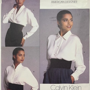 Könnte beinhalten: Ein Vintage-Schnittmuster mit Bildern einer Frau in weißen Blusen und hoch taillierten Röcken. Das Muster enthält die Logos von Vogue und Calvin Klein, mit Text, der darauf hinweist, dass es sich um ein amerikanisches Designermuster von 1981 handelt.