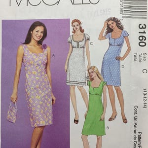 May include: A McCall's sewing pattern featuring illustrations of four different dresses. The pattern includes a floral print dress, a polka dot dress, and two other dress designs. The pattern number is 3160, with sizes 10-12-14.