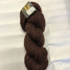 Op de afbeelding: Een bol bruin garen met kleurvlekken. Het garen is gelabeld "The Yarn Harlot" en "Peed", met een prijskaartje van $ 14,50.