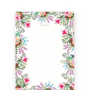 May include: Floral notepad with a white background and lined paper. The border is decorated with pink, purple, yellow, and blue flowers.