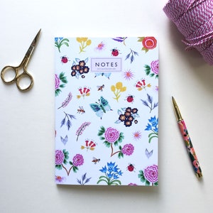 Libreta de hojas rayadas tamaño A5 con motivos botánicos de flores y abejas