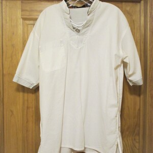 May include: A white, short-sleeved shirt with a lace-up neckline and a single pocket on the left side. The shirt has a longer length in the front and back, and the sleeves have a blue and white striped trim.