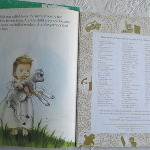 May include: A young boy in a white robe holds a small lamb in his arms. The text on the page reads "The child was called Jesus, the name given by the angel before he was born. And the child grew and became strong in spirit and full of wisdom. And the grace of God was upon him."