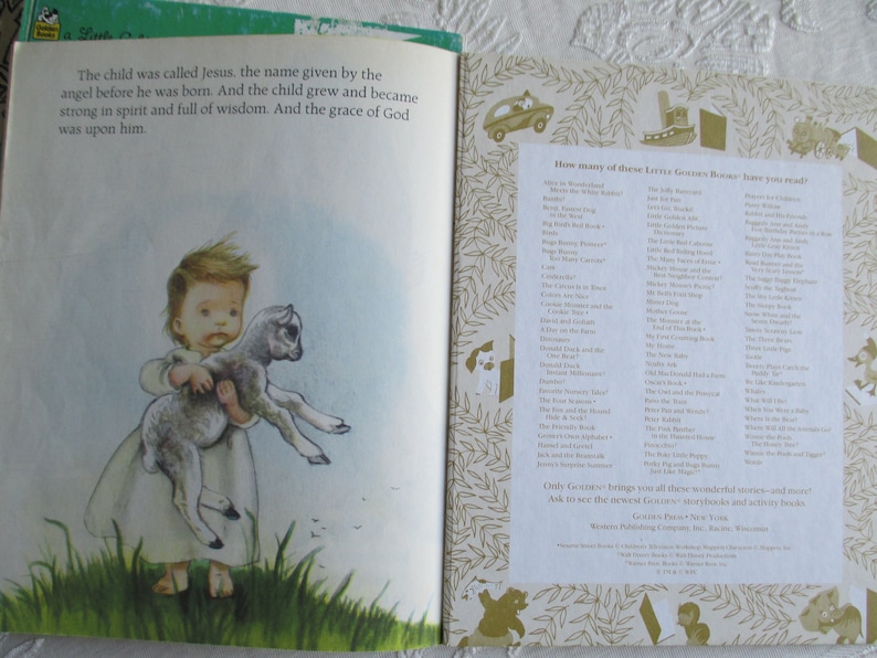 May include: A young boy in a white robe holds a small lamb in his arms. The text on the page reads "The child was called Jesus, the name given by the angel before he was born. And the child grew and became strong in spirit and full of wisdom. And the grace of God was upon him."