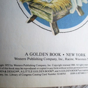 May include: A Golden Book cover with a blue background and a picture of a baby in a manger. The book title is "A Golden Book" and the publisher is Western Publishing Company, Inc. The copyright date is 1952.