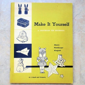 May include: A yellow book titled "Make It Yourself: A Craftbook for Beginners" with illustrations of crafts, including a wooden box, a bird, a plane, a snowman, an owl, a rocking chair, and a star. The book is published by D.C. Heath and Company.