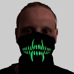 May include: A black face mask with a glowing green teeth design. The mask is made of a soft, comfortable material and is perfect for parties, festivals, or any event where you want to stand out.
