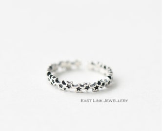 Könnte beinhalten: Ein silberner Ring mit einem zarten Design aus kleinen Sternen. Der Ring ist schlicht und elegant und perfekt für den Alltag.