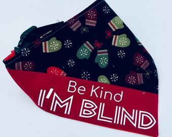 May include: Red and black dog bandana with a white print that says "Be Kind I'M BLIND" and a pattern of green and red mittens on a black background.