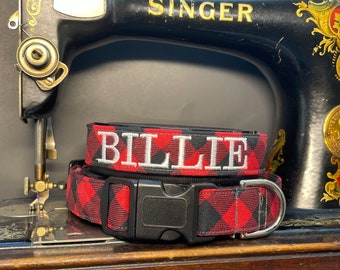 May include: Red and black plaid dog collar with a black buckle and a white embroidered name tag that says "BILLIE".