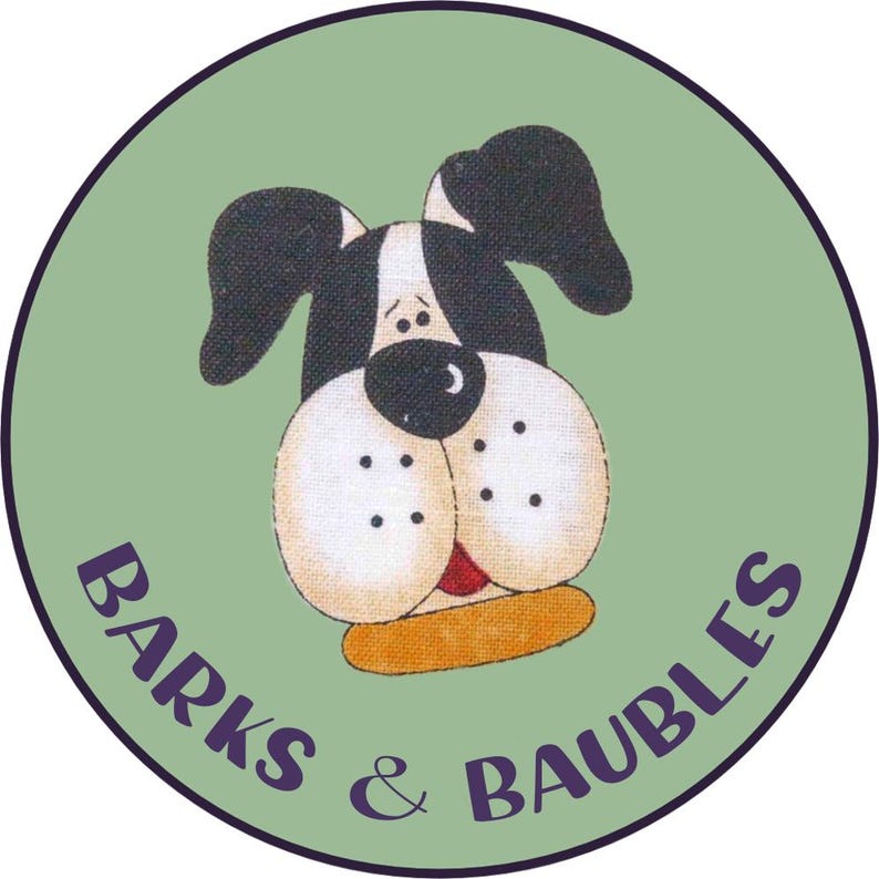 May include: A circular logo featuring a cartoon dog's face with black and white fur, large beige cheeks, and a red tongue. The dog is set against a light green background, with the words "BARKS & BAUBLES" in purple script.
