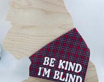 May include: Red and black plaid dog bandana with white text that reads "Be Kind I'm Blind".