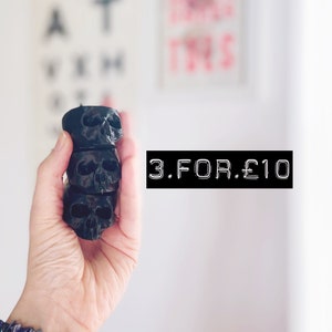 May include: Three black skull-shaped candle holders stacked on top of each other. The text "3. FOR. £10" is visible in the image.