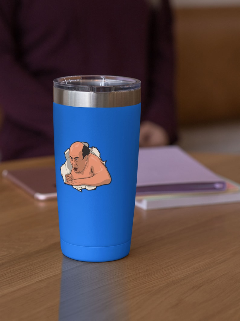Peut inclure: Un gobelet isotherme en acier inoxydable bleu avec un autocollant blanc repr&eacute;sentant un homme de dessin anim&eacute; chauve, avec une expression surprise, qui sort d'un morceau de papier d&eacute;chir&eacute;.