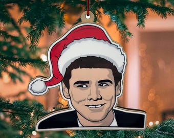 Peut inclure: Une décoration de Noël en bois représentant un homme en dessin animé portant un bonnet de Père Noël. La décoration est de couleur rouge, blanche et marron.