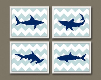 May include: Set of four framed prints featuring blue shark silhouettes on a light blue chevron background.