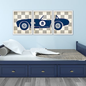 Peut inclure: Un ensemble de trois tableaux muraux bleu et blanc repr&eacute;sentant une voiture de course vintage sur un fond &agrave; damier. La voiture porte le num&eacute;ro "8" sur le c&ocirc;t&eacute;.