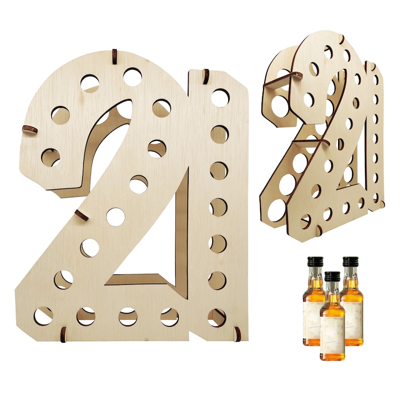 May include: A light-colored wooden display stand shaped like the number 21, featuring multiple circular cutouts designed to hold small bottles. The structure is assembled from flat wooden panels with visible slots and includes three miniature bottles.