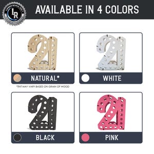 May include: A set of four wooden number 21 displays, each featuring a series of circular cutouts along the front face. The displays are available in natural wood, white, black, and pink finishes, with the text AVAILABLE IN 4 COLORS visible.