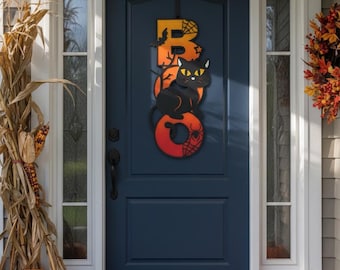 May include: A vertical hanging door sign featuring the word BOO in a gradient orange to red colour scheme. The letter B includes a black bat and spiderweb, while the letter O features a black cat with yellow eyes and a spiderweb design.