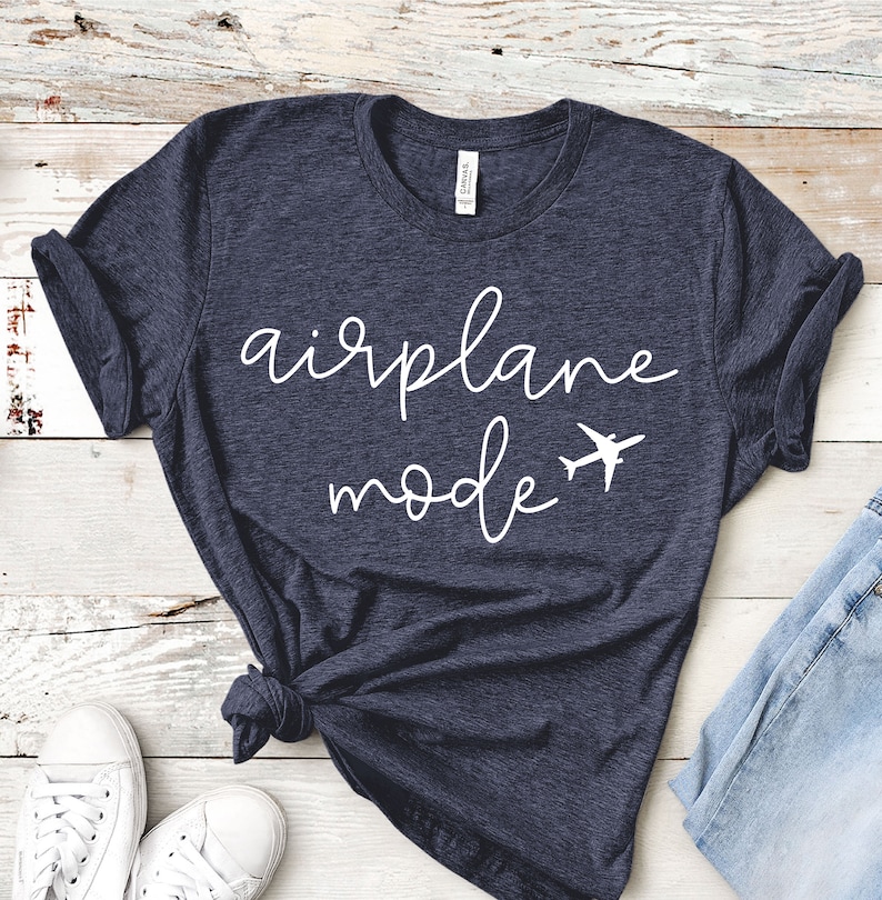 May include: A dark blue t-shirt with the text "airplane mode" in white cursive lettering and a small airplane graphic.