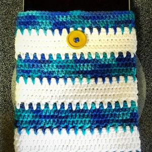 May include: Crocheted tablet sleeve in shades of blue, white, and teal. The handmade case features a button closure and a striped pattern. The sleeve is designed to protect a tablet device.