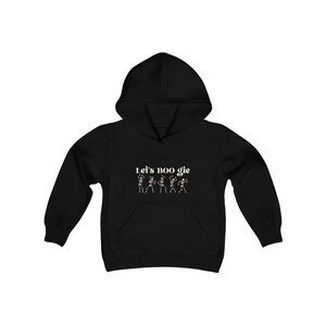 Op de afbeelding: Zwart hoodie met de tekst "Let's BOO gie" en een afbeelding van vijf dansende skeletten.
