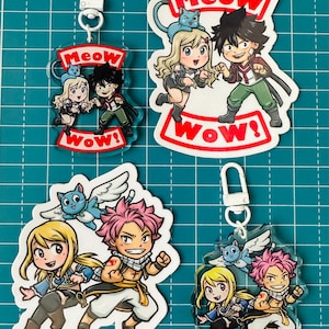 May include: Two sets of anime character keychains. The first set features a girl with blonde hair and a boy with black hair. The second set features a girl with blonde hair and a boy with pink hair. Both sets have a cat with wings. The keychains are white with red and black accents. The text on the keychains reads "Meow Wow!"