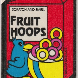 May include: A vintage "Fruit Hoops" sticker with a red box design. The sticker features a blue bird, a yellow and blue bowl filled with colorful cereal rings, and the text "SCRATCH AND SMELL" and "FRUIT HOOPS".