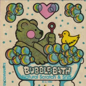 以下が含まれることがあります： 7つのステッカーのシート。メインのステッカーは、青いバスタブでシャボン玉を吹いている緑色のクマ、黄色いアヒル、ヨットが描かれています。「Bubble Bath Natural Scratch & Sniff」の文字。ヴィンテージ漫画スタイル。