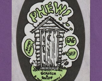 May include: A black and white sticker with a cartoon outhouse and the text "PHEW!" in a green cloud above it. The outhouse has a crescent moon on the door and the text "BOMBS AWAY!" and "GAG" and "GASP" in green speech bubbles. The text at the bottom reads "1983 WEAVER WERKS SCRATCH & SNIFF & YOU'LL BE SORRY!"