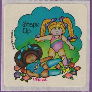 May include: A vintage sticker featuring two cartoon dolls in exercise attire. One doll is standing, the other is lying down. The sticker has the text "Shape Up" and "Herbal". The dolls are surrounded by flowers and a teal cloud-shaped background.