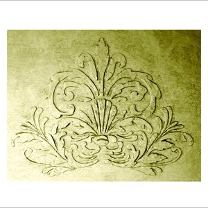 May include: A detailed, olive-green, embossed floral design. The symmetrical pattern features stylized leaves, scrolls, and a central fan-like element. The background has a textured, aged appearance, enhancing the vintage aesthetic.