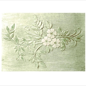 May include: A light green, textured surface features a floral relief design. The design includes white flowers, leaves, and stems, creating a delicate, nature-inspired pattern. The relief is raised, adding dimension to the artwork.