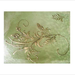 May include: A decorative piece featuring a gold floral design on a pale green background. The design includes stylized leaves, flowers, and swirling stems. The artwork has a textured appearance, with the gold elements standing out against the green.