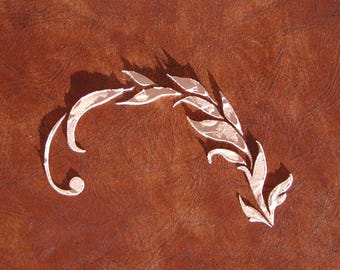 May include: A decorative, stylized wheat stalk design in a light beige color, with a textured pattern, is set against a brown background. The design has a curved stem and detailed leaves, creating a natural, elegant aesthetic.