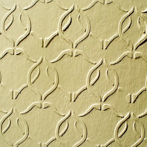 Puede incluir: Primer plano de una superficie texturizada de color amarillo claro con un patr&oacute;n repetitivo de formas curvas y estilizadas. El patr&oacute;n est&aacute; en relieve, creando sombras y profundidad, y el efecto general es decorativo.