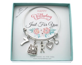 May include: A silver charm bracelet with a floral design and the text "Happy Birthday Just For You". The bracelet has charms that include the number 7, a birthday cake, the letter R, and a heart.