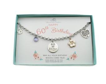 May include: A silver-toned charm bracelet with multiple charms, including a letter "B", a purple gem, a flower, and a disc that reads "60 Fabulous". The card behind the bracelet says "Happy 60th Birthday".