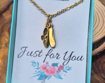 May include: A gold-toned necklace featuring a ballet slipper charm pendant, presented in a light blue gift box. The display card includes the text Mom and Three Daughters, Just for You, and the website address www.momandthree.com with floral art.