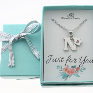 Little girl&#39;s personalized initial necklace in silver toned metal and acrylic on a stainless steel cable chain. Girls gift initial necklace.