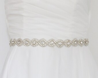 Op de afbeelding: Een witte bruidsband met een parelmoerontwerp met heldere strass.